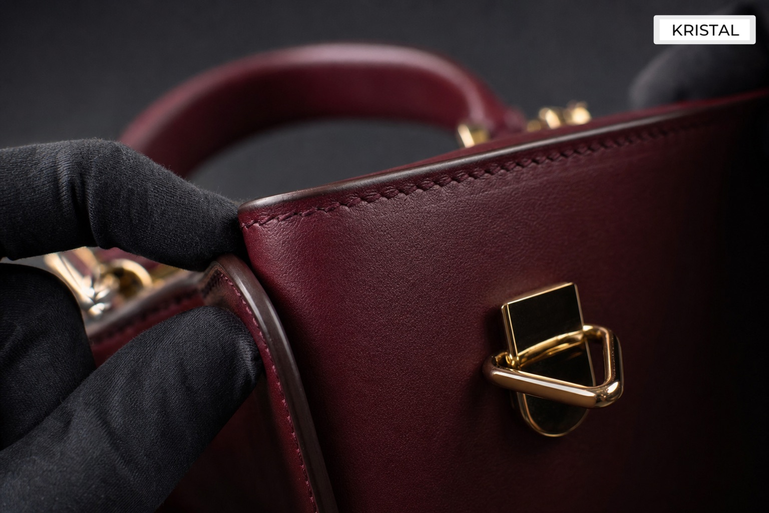 Macro inspection of a luxury handbag edge, stitching and hardware with a gloved hand