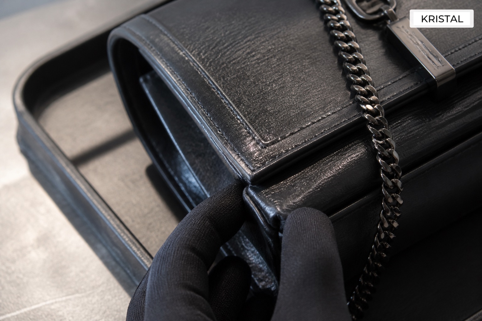 Editorial inline image showing close Saint Laurent valuation inspection of corners, leather grain, flap edge, and logo hardware in Malaysia