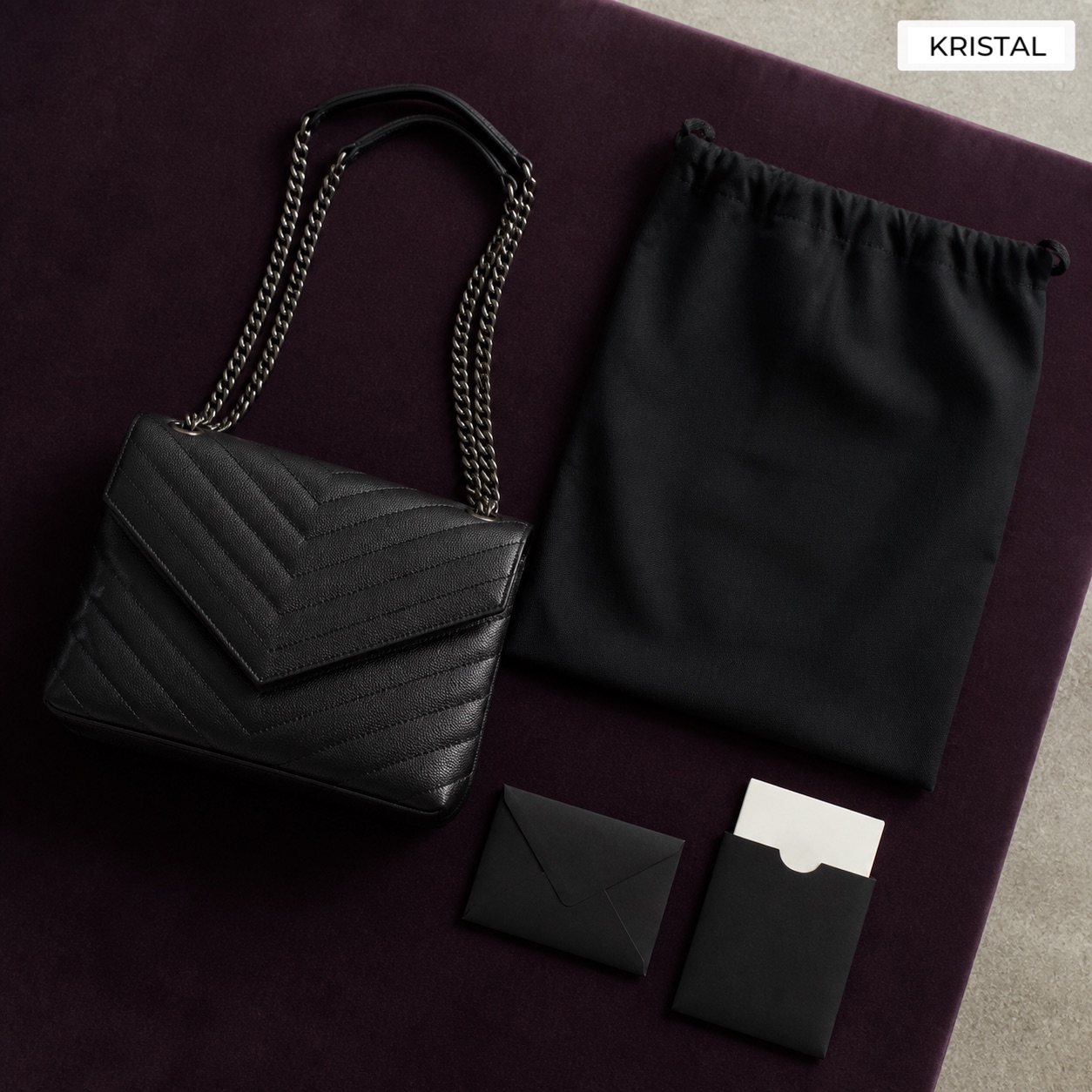 Editorial inline image showing a Saint Laurent valuation file with chain strap, dust bag, card, and accessories arranged for review in Malaysia