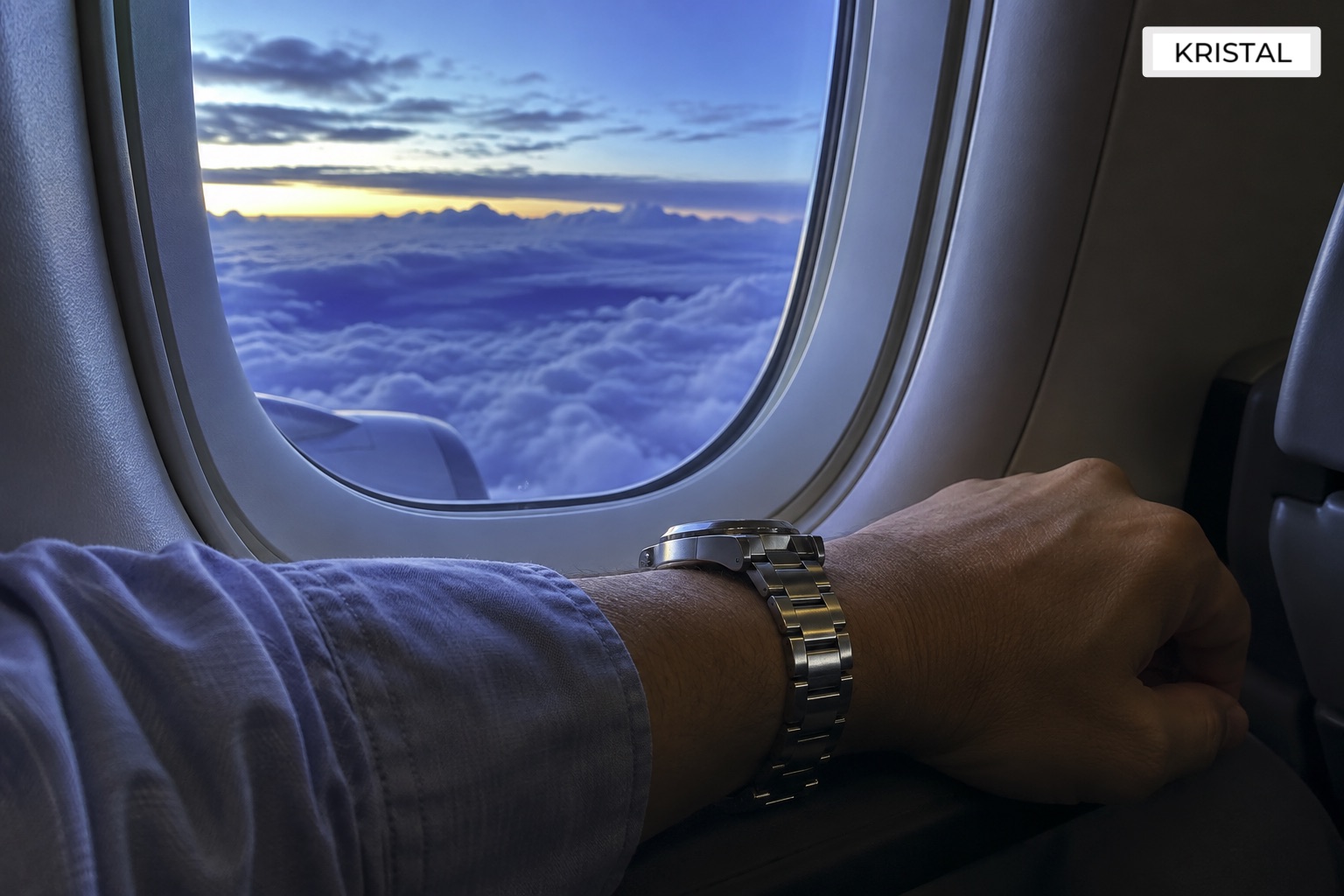 Illustrative travel scene showing a steel watch beside an aircraft window