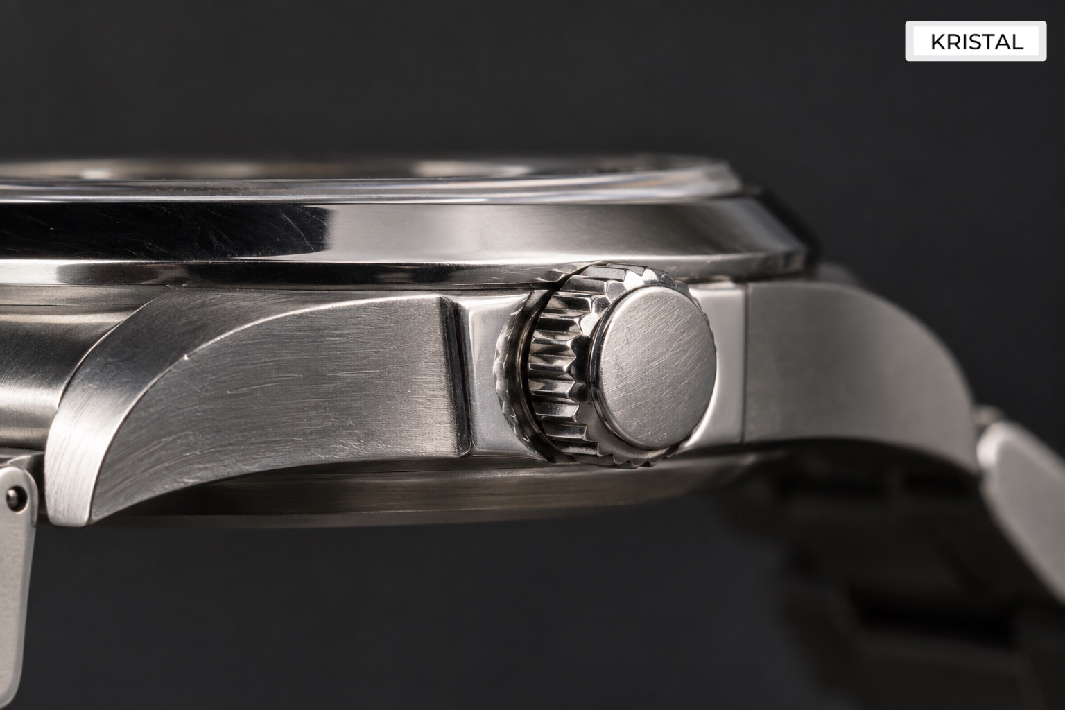 Close detail of a winding crown seated against a steel watch case