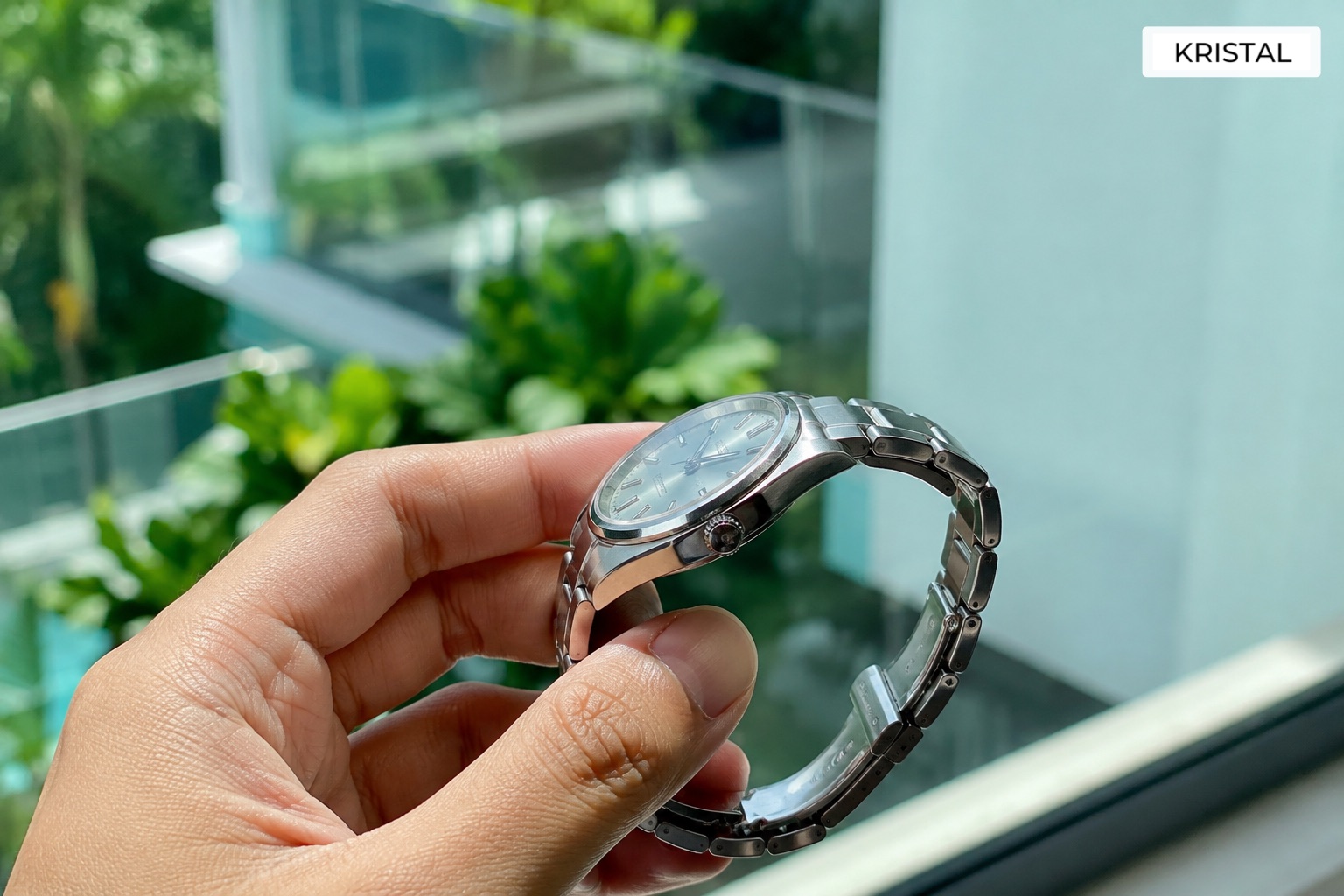 Watch owner checking an unbranded luxury watch in natural Malaysian daylight before resale review